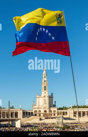 Fatima, Portugal - May 12, 2019: Flag of Venezuela fluttering in the Shrine of Fatima, Portugal, with the basilica in the background. Stock Photo