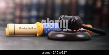 Immigration Law wrapped in a USA flag, Imigration Regulation concept, Judge Gavel on the wooden background. Stock Photo