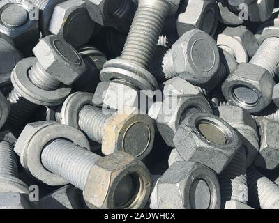 Steel nuts and screws piled in the box. Fastening construction equipment. Fixing hardware. Stock Photo