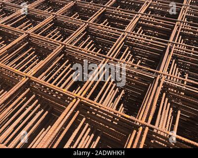 Piled iron reinforcement workpieces. Metal mesh for reinforcement. Iron rusty rectangular structure. Stock Photo