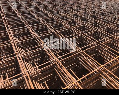 Piled iron reinforcement workpieces. Metal mesh for reinforcement. Iron rusty rectangular structure. Stock Photo