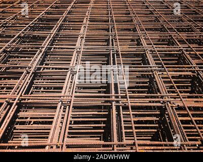 Piled iron reinforcement workpieces. Metal mesh for reinforcement. Iron rusty rectangular structure. Stock Photo