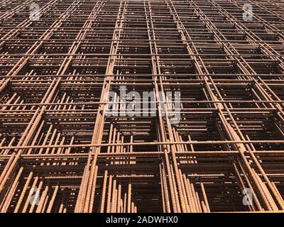 Piled iron reinforcement workpieces. Metal mesh for reinforcement. Iron rusty rectangular structure. Stock Photo