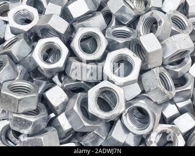 Steel nuts piled in the box. Fastening construction equipment. Fixing hardware. Stock Photo