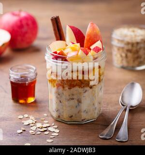 Overnight oats, bircher muesli with apple in glass jar. Wooden background. Close up. Stock Photo