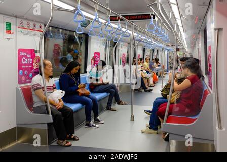 Singapore-25 FEB 2018:Indoor view of people in a rail commuters ride a crowded Mass Rapid Transit MRT train Stock Photo
