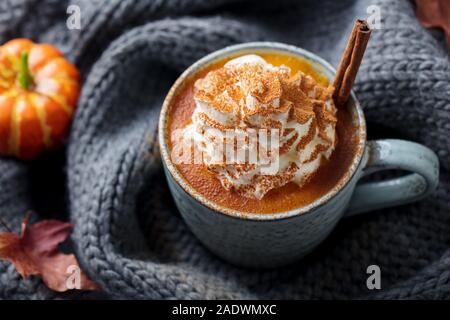 Pumpkin latte with spices. Boozy cocktail with whipped cream. Grey knitted background. Top view Stock Photo