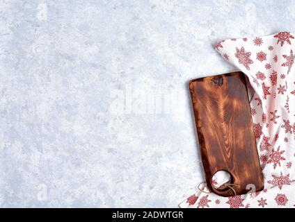 Empty kitchen cutting board with red christmas tablecloth. Stock Photo