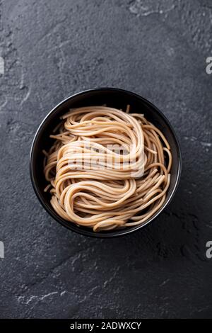 Soba noodles on a black bowl. Japanese food. Slate background. Top view Stock Photo