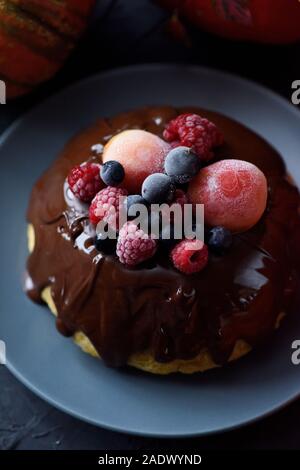 Hygge dessert. Homemade chocolate pudding with frozen berries on dark background copy space Stock Photo
