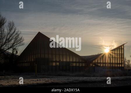 Magdeburg, Germany. 05th Dec, 2019. Behind the hypar dish, the sun rises. The listed building has been renovated since this week. Planned total costs: 17 million euros. According to the plan, the work will be completed in the summer of 2022. Credit: Stephan Schulz/dpa-Zentralbild/ZB/dpa/Alamy Live News Stock Photo