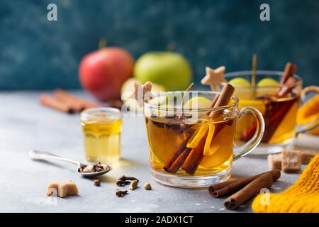 Apple mulled cider with spices in glass cup. Grey stone background. Copy space Stock Photo