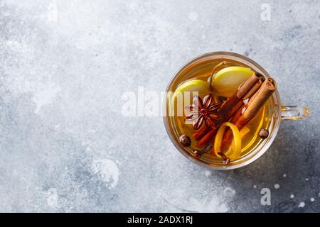Apple mulled cider with spices in glass cup. Grey background. Copy spase. Top view Stock Photo