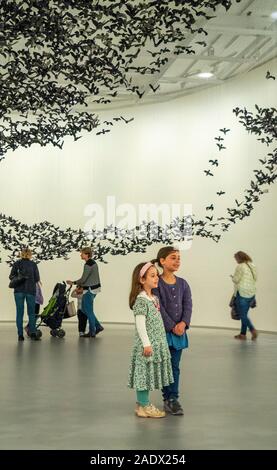 Boy and girl posing for photo at Murmuration (Landscape) installation at National Gallery of Victoria NGV  Melbourne Victoria Australia.