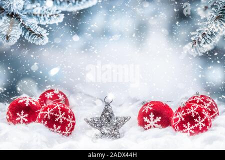 Red christmas balls on snow with fir branches Stock Photo
