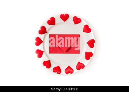 White plate surrounded by hearts and paper envelope on white background Stock Photo