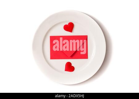 White plate surrounded by hearts and paper envelope on white background Stock Photo