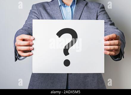 Young businessman holding white card with question mark on it Stock Photo