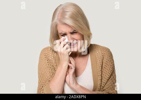 Desperate old woman crying wiping tears with handkerchief Stock Photo