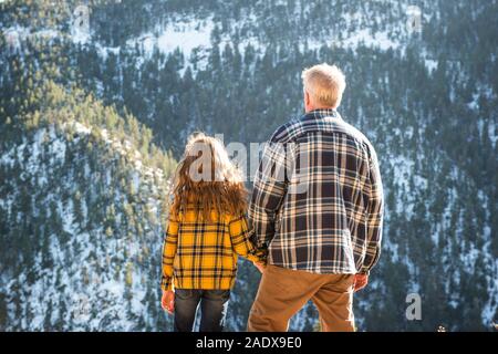 Grandfather and Granddaughter Hiking in the Mountains Stock Photo