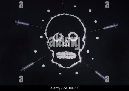 Social advertisement. The concept is death from drugs. Skull made of white powder on a black background with syringes and pills. For young people. Stock Photo