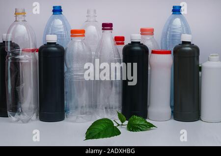 Concept: ecology, life, environmental conservation. Plastic bottles and green sprout on a white background. Garbage, environmental pollution Stock Photo