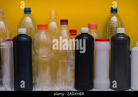 Concept: ecology, life, environmental conservation. Plastic bottles and green sprout on a yellow background. Garbage, environmental pollution Stock Photo
