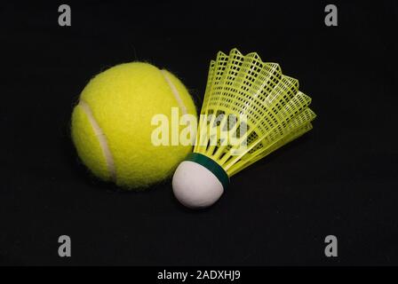 Yellow tennis ball and shuttlecock isolated on black Stock Photo