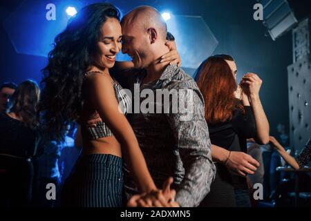 Smiling during the process. Couple dancing at nightime in the club. Enjoying music and each other Stock Photo