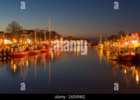Traditional fishing boats in the canal der Alte Strom / Old Channel at Warnemünde in the city Rostock at dusk, Mecklenburg-Vorpommern, Germany Stock Photo