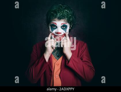 boy dressed as Joker on dark background Stock Photo