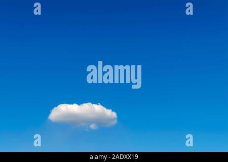 Single white fluffy cumulus cloud against a blue sky. Stock Photo