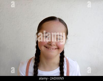 Portrait of little girl smiling on background of the wall Stock Photo