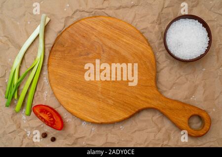 Round wooden oak cutting board for products. Top view. Cooking food. Stock Photo