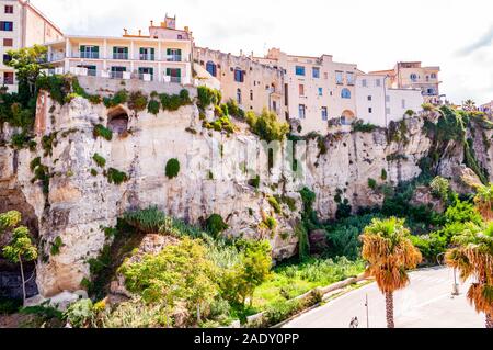 Famous sea promenade in Tropea with high cliffs with built on top city buildings and apartments. Parking area on the street. Amazing Italian cityscape