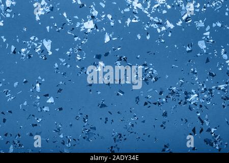 Glowing mica sparkles on blue color trendy background. Holiday confetti. Classic Flat lay. New Year 2020 Stock Photo