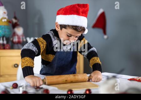 Beautiful boy making cookies on Christmas Day Stock Photo