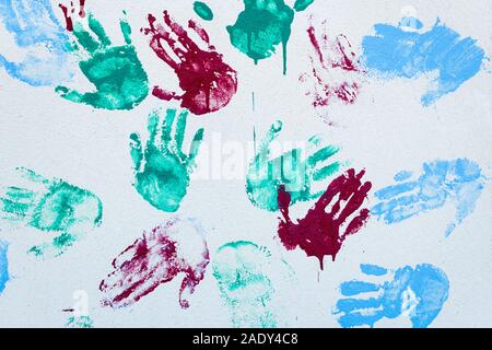 colorful hand prints on a white wall, made by children Stock Photo