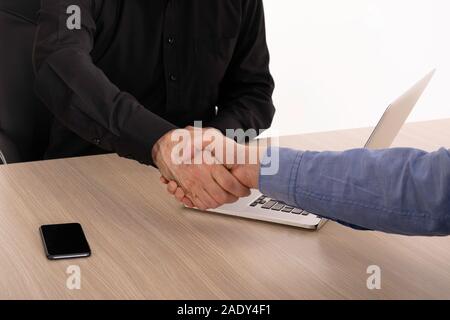 Good deal. Close-up of two business people shaking hands while sitting at the working place. Successful deal after great meeting. Stock Photo