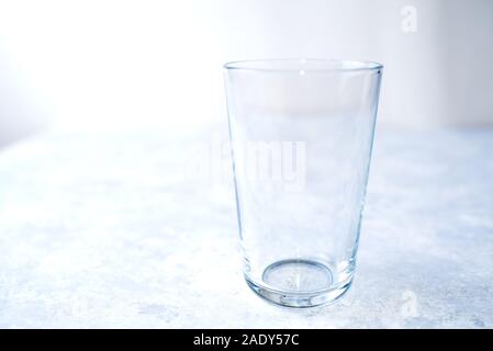 Empty glass isolated on a blue background close up Stock Photo