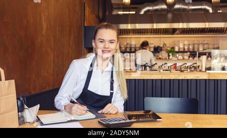 Small business owner calculating bills and profit using digital tablet Stock Photo