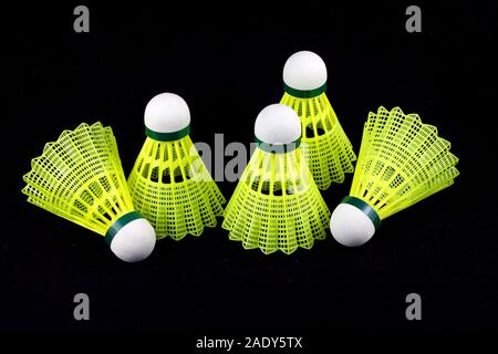 Five yellow badminton shuttlecocks with white cork isolated on black Stock Photo