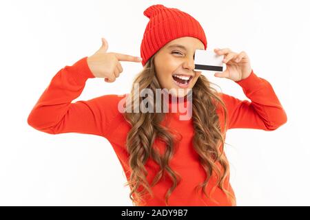 smiling european cute girl holding a credit card in her hands on a white background. Stock Photo