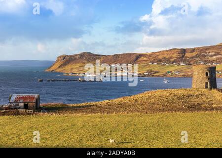 Uig Harbour and ferry terminal on the north coast of Ross and Cromarty district of the Isle of Skye with the headland of the cliffs of Scuidburgh at U Stock Photo