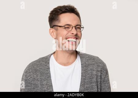 Happy young man laughing at funny joke squinting his eyes Stock Photo