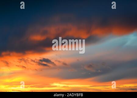 Dark thunderclouds on a golden sky during sunset. Afterglow of sunset. Scenic sundown cloudscape for background. Beauty in nature. Stock Photo