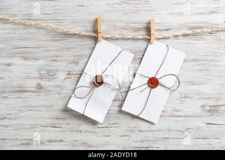 White envelopes hanging on rope Stock Photo