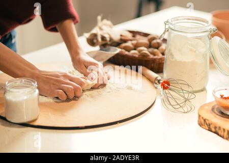 Female cook kneading dough on the table Stock Photo