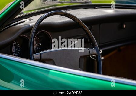 antique green car steering wheel and black Dashboard close up, simple old style cars interior, Speed Counter and tachometer, RPM gauge Stock Photo