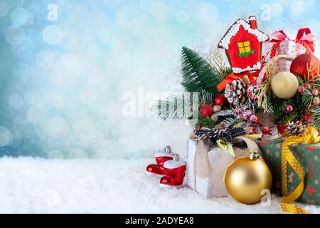 Christmas composition with decorations, gingerbread house, gift boxes and snow on blurred background. Christmas holidays background with copy space Stock Photo